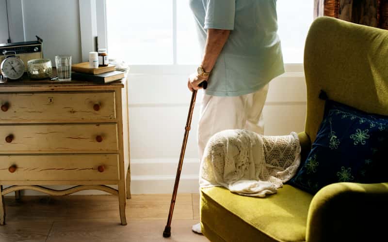 Elderly woman standing in her living room. Hammerle Finley Law Firm located in Lewisville, Texas