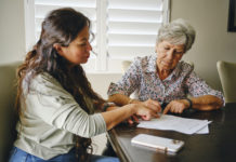 Woman Helping a Senior With Documents