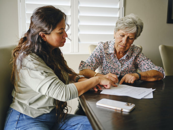 Woman Helping a Senior With Documents