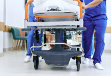 medical staff rolling bed down the hallway