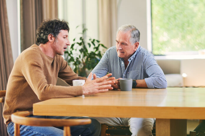 man and elderly father having coffee at home