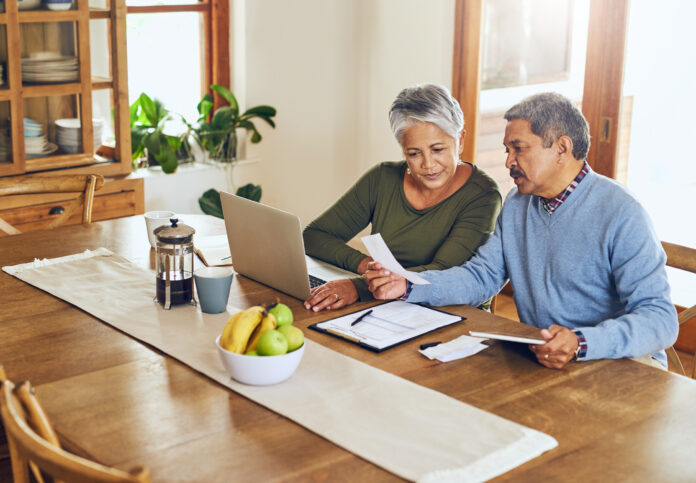Shot of a mature couple managing their paperwork together at home