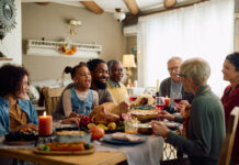 Cheerful family enjoying in conversation during Thanksgiving meal at dining table.