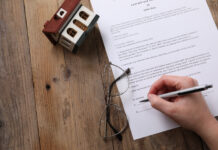 Woman signing Last Will and Testament at wooden table, top view. Space for text