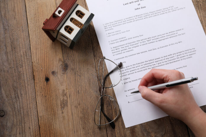 Woman signing Last Will and Testament at wooden table, top view. Space for text